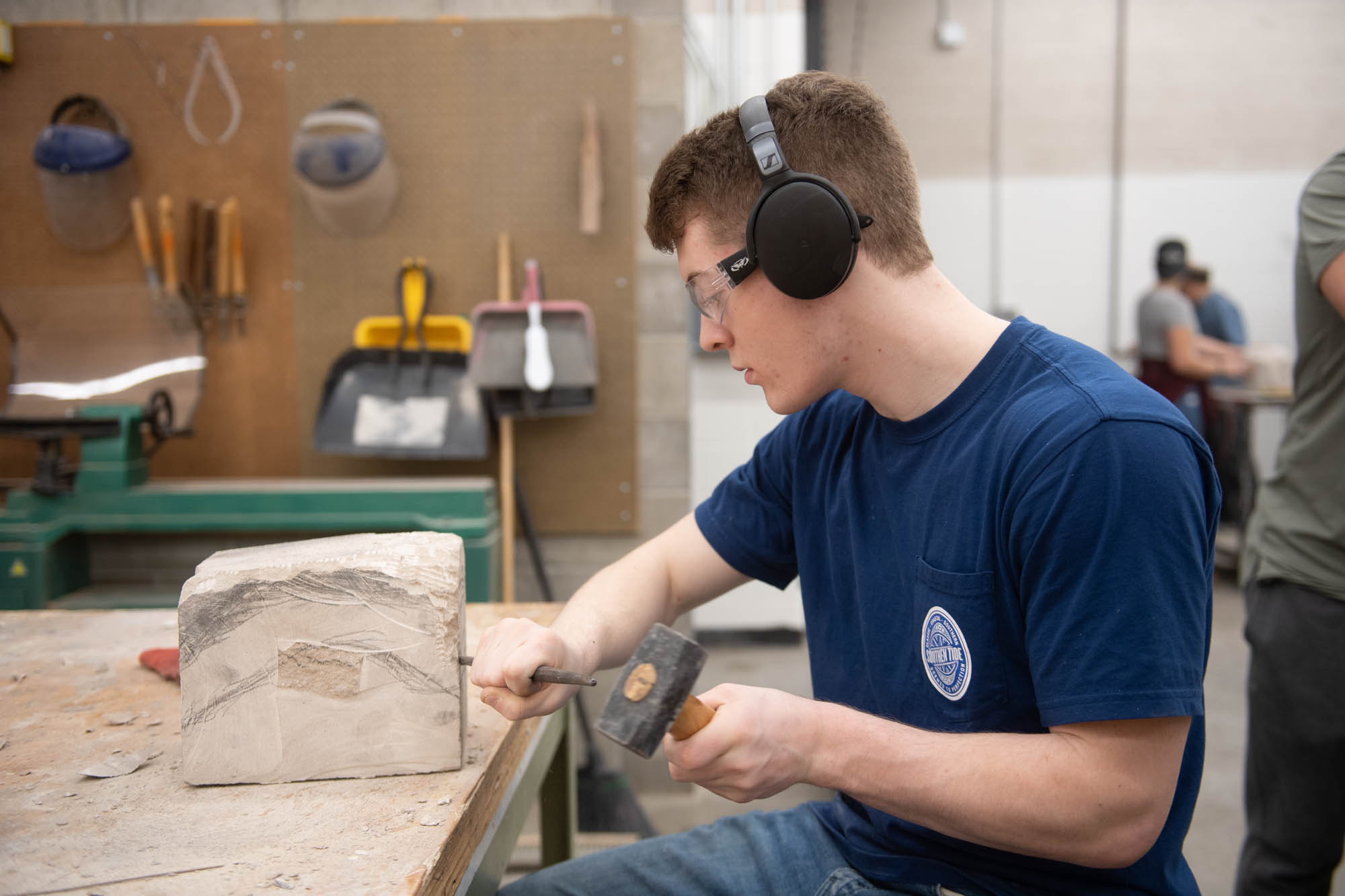 Art student chiseling limestone at Illinois Wesleyan University