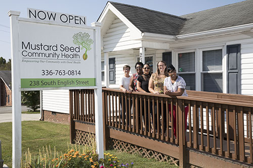 The Mustard Seed Community Health staff poses for a photo outside the clinic’s front door. 
