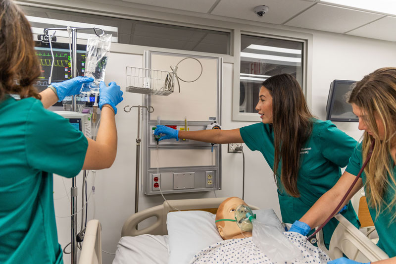In the nursing simulation room Olivia Shell ‘24 (middle) and Faith Washko ‘24 (right) treat dummy patients with a full suite of critical care instruments.