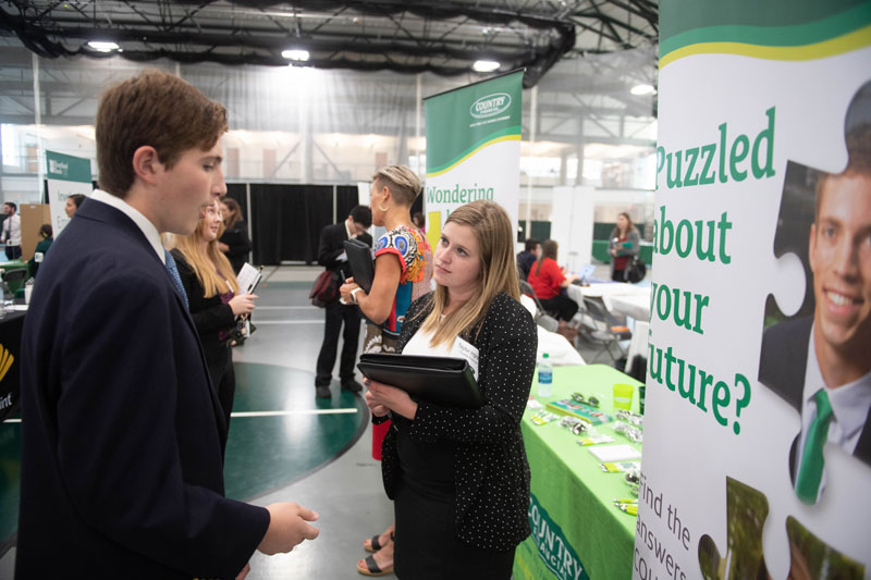 Student talking to COUNTRY Financial recruiter at an IWU Career Fair.