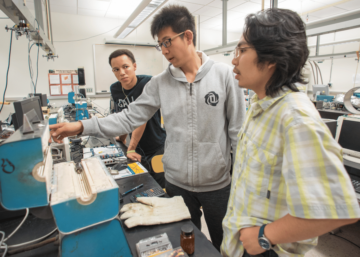 Students examine equipment in an experimental physics classroom at IWU