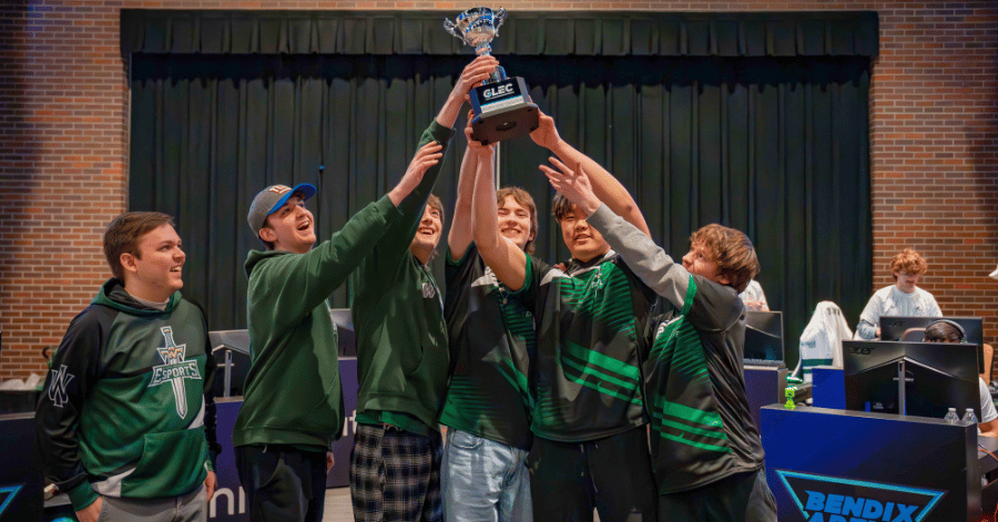 IWU esports players lifting up trophy at championship match