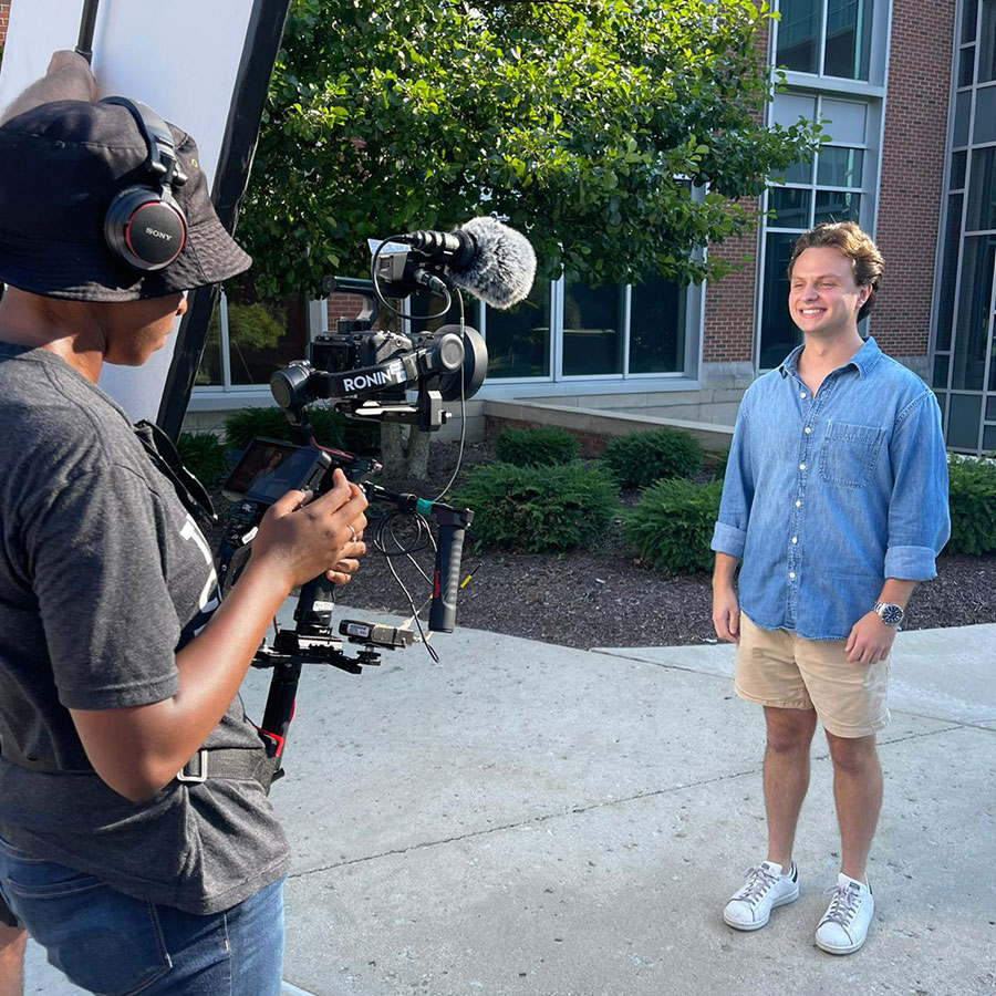 Student smiling while being filmed for The College Tour episode about IWU.