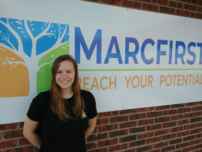 Macey in front of the Marcfirst sign