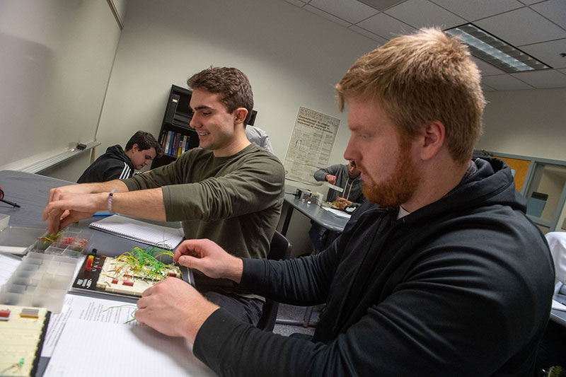 Students building a circuit in an electronics lab