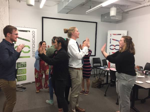 A group of students taking a brain break and playing hand games