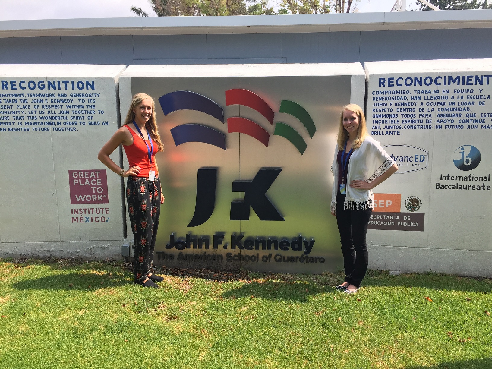 Amber and Katie standing by a JFK sign