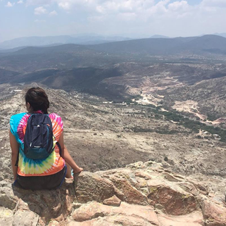 Yesenia reflecting at the top of a mountain