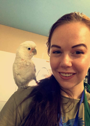 Lindsey Peters with a cockatoo on her shoulder.