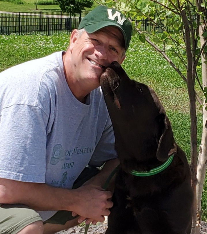 Dirk Behrends smiling at camera with his dog