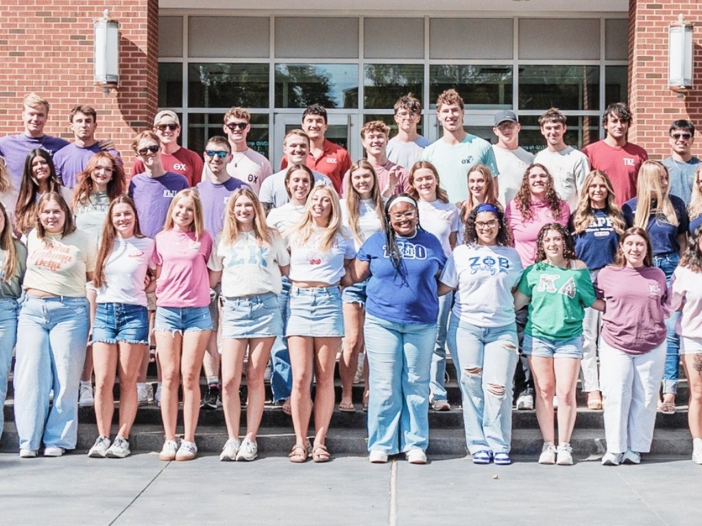 Greek life students at bench on quad