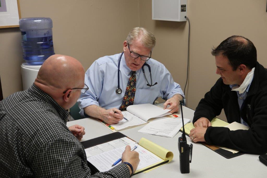 Davis meets with a Rockford Police Department officer and detective to discuss the results of an exam.