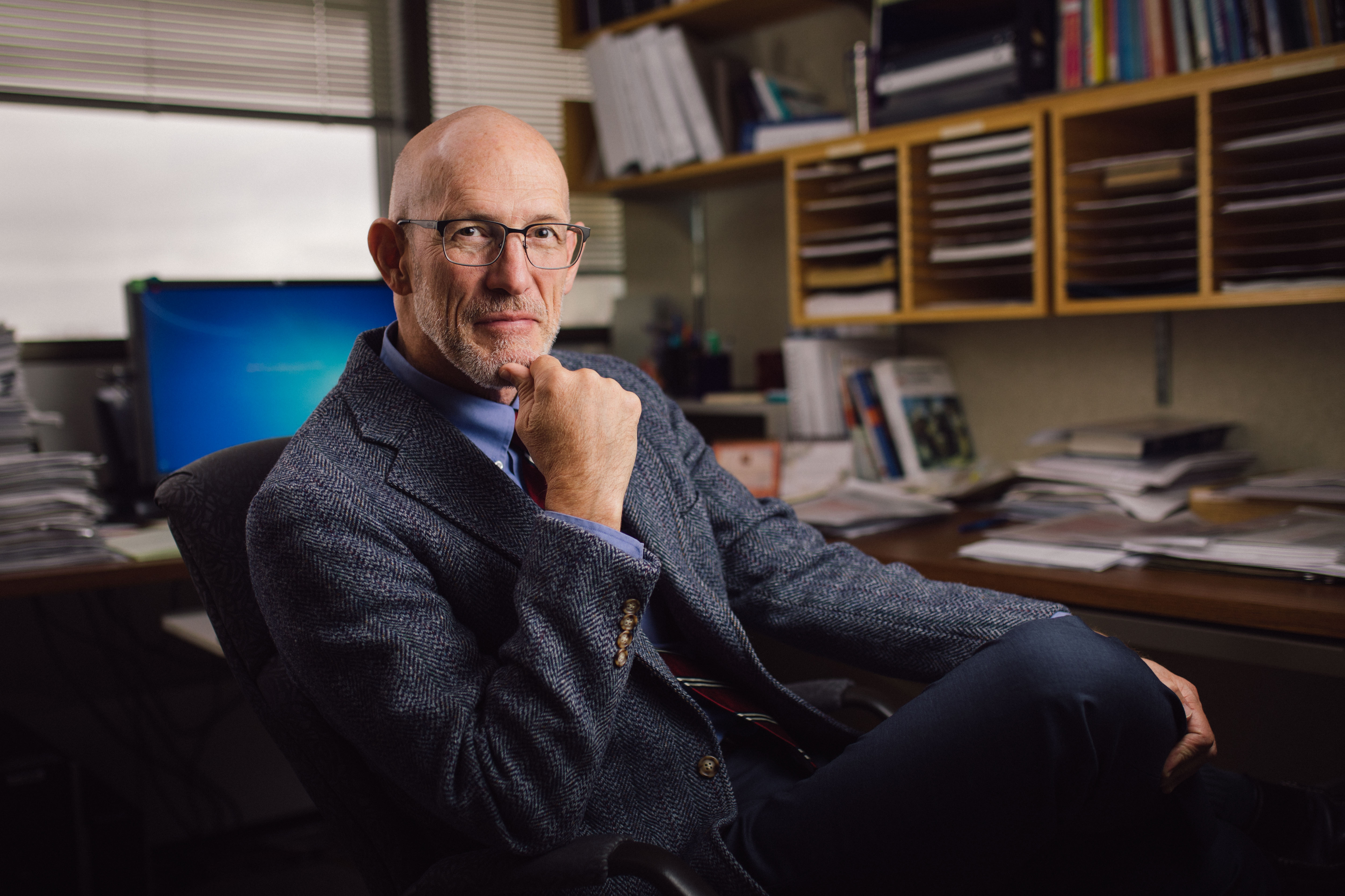 Dr. Gregory A. Poland ’77, a leading voice for science during the COVID-19 pandemic, poses at his desk.