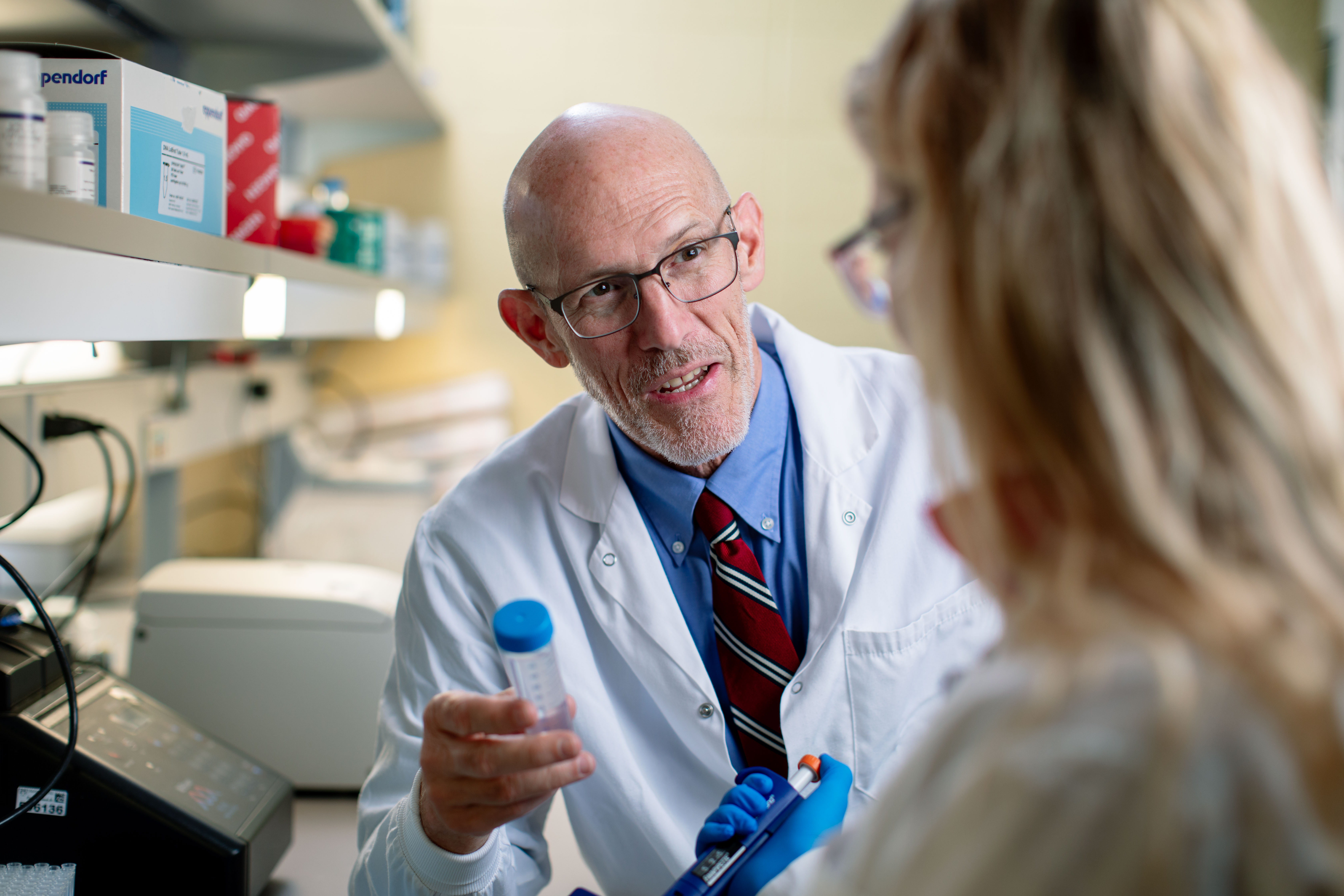 Poland speaks with a team member at his Mayo Clinic Lab.