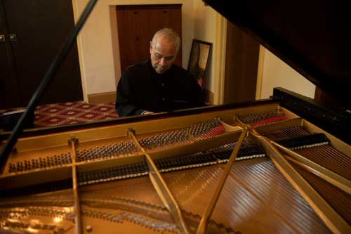 Larey plays the piano in his Presser Hall office.