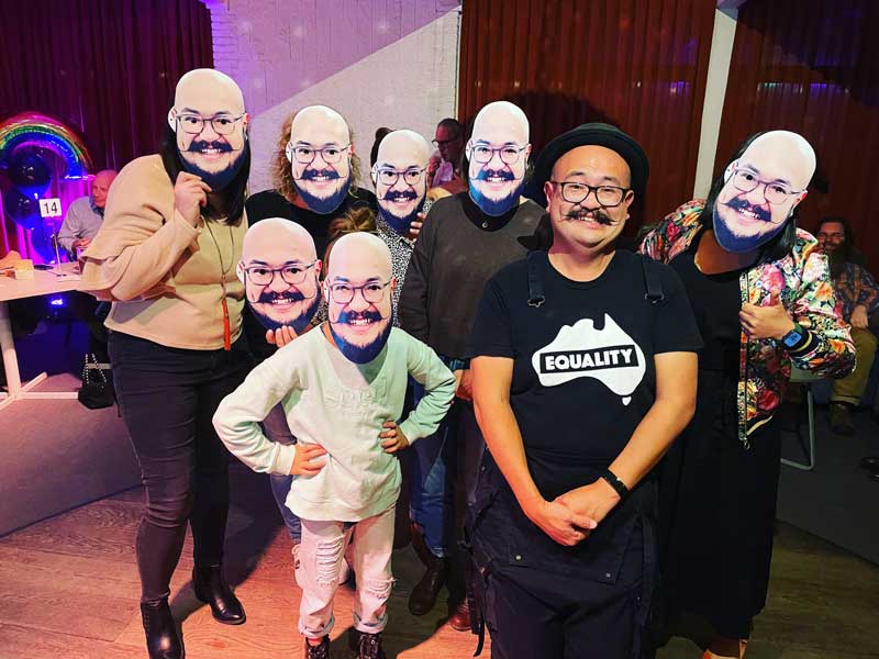 Noor is surrounded by his colleagues at a watch party for the season finale of The Great Australian Bake Off.