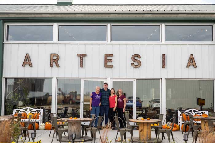 Left to right) Morris Tammen ’75, Evan Tammen ’09, Katrina (Tammen) Reber ’05 and Linda (Brown) Tammen ’76 in front of their new tasting room at Artesia. 