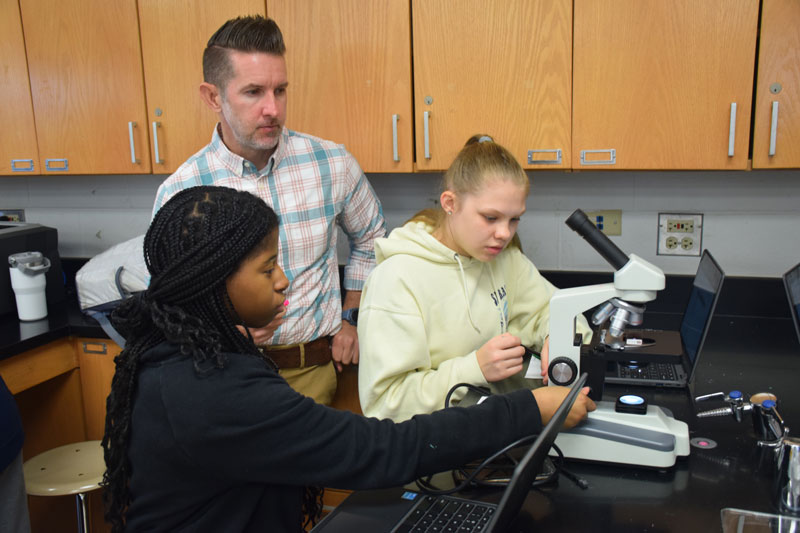 Scott, pictured with students in his Lemont classroom, inspired to enter the field of education by professor of biology Tom Griffiths.