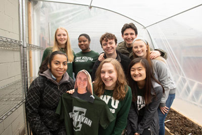 Students pose at greenhouse. 