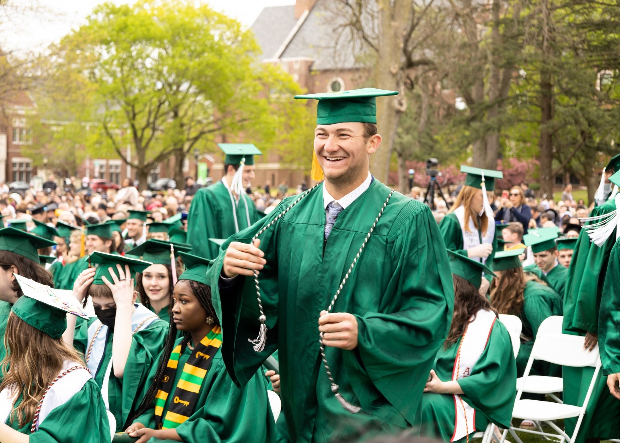 crowd of graduates with one walking