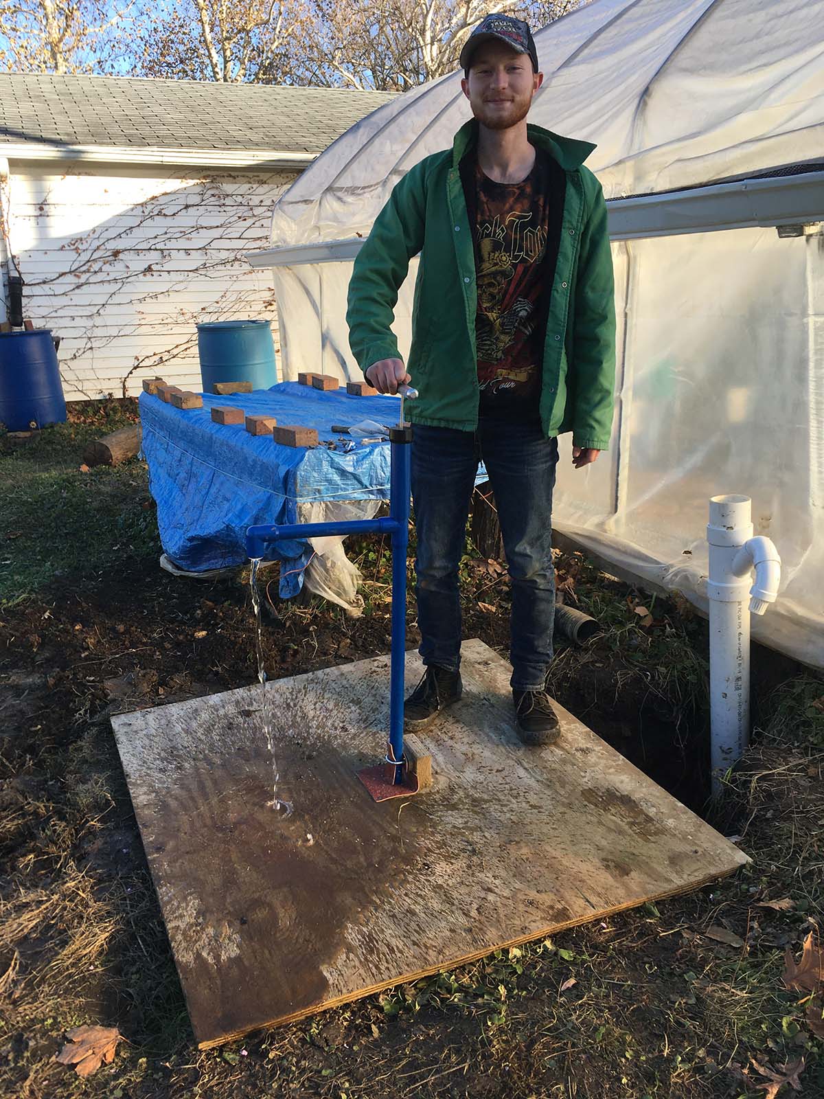 Ryan Reish tests the water pump at IWU's Peace Garden