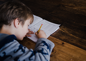 Young student writing in work book