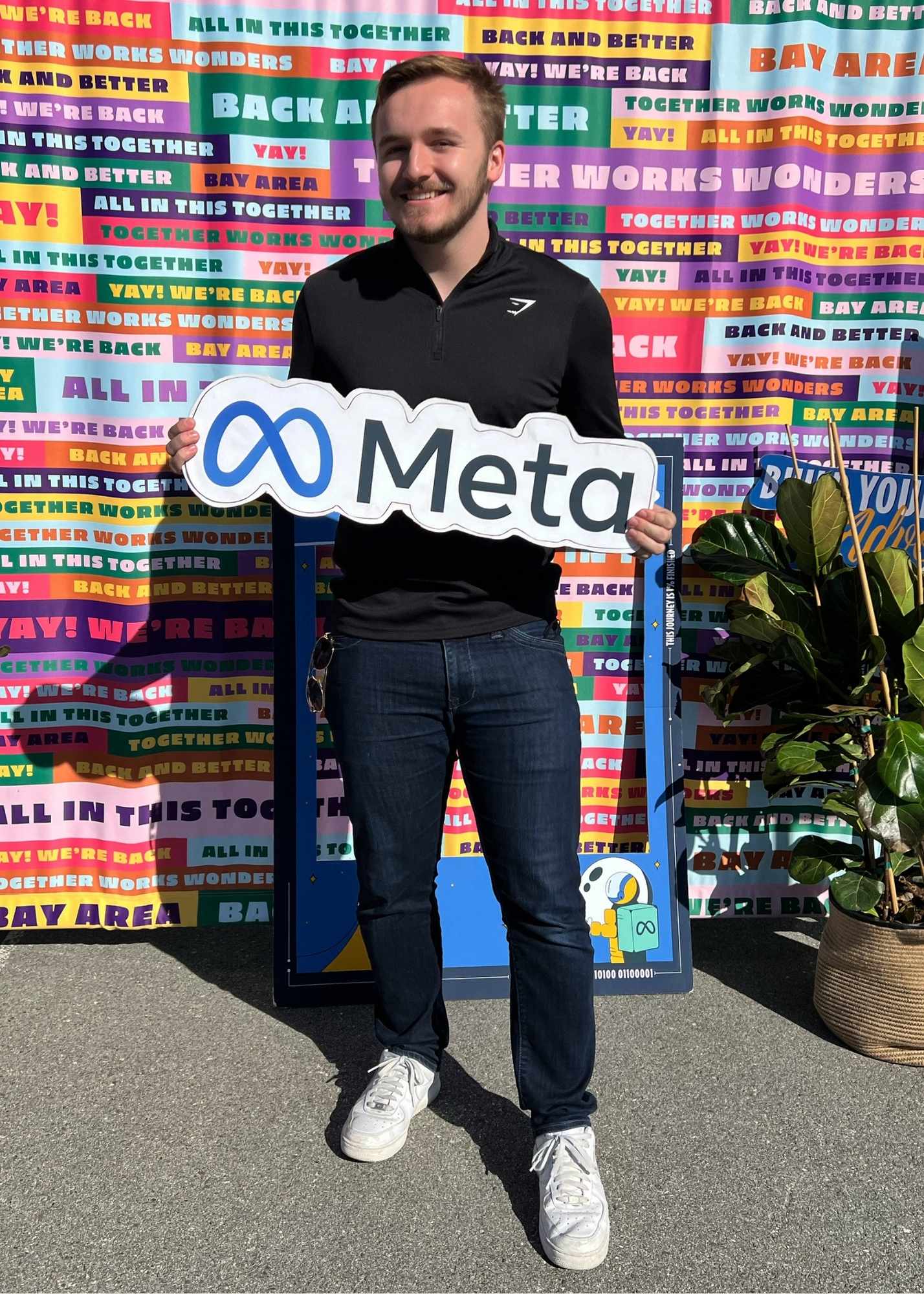 Evan Quist holding Meta sign during internship