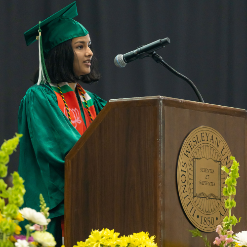 Mishwa Bhavsar '23 speaks on stage at Illinois Wesleyan Commencement