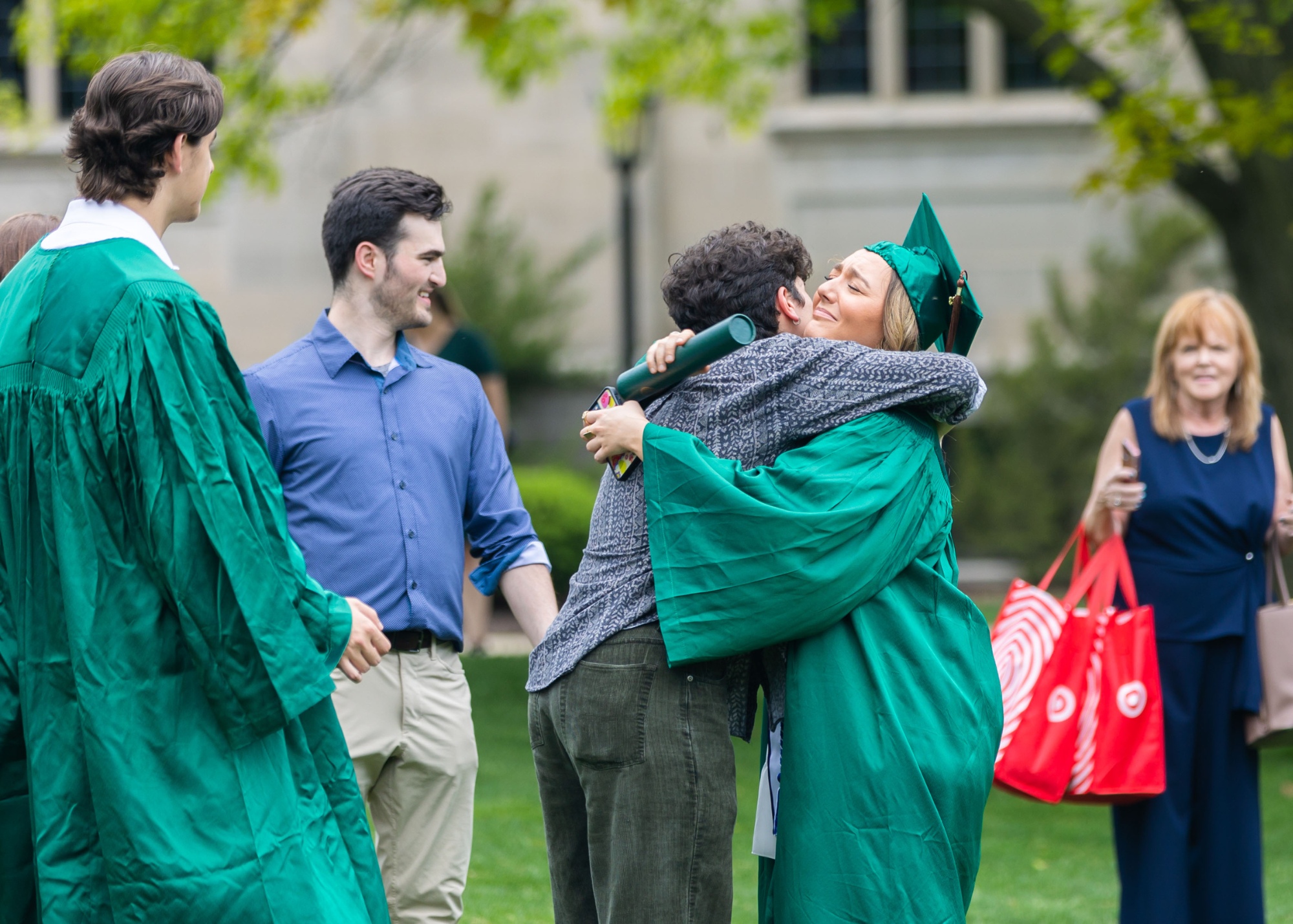 Illinois Wesleyan graduates hugging friends on the quad after commencement