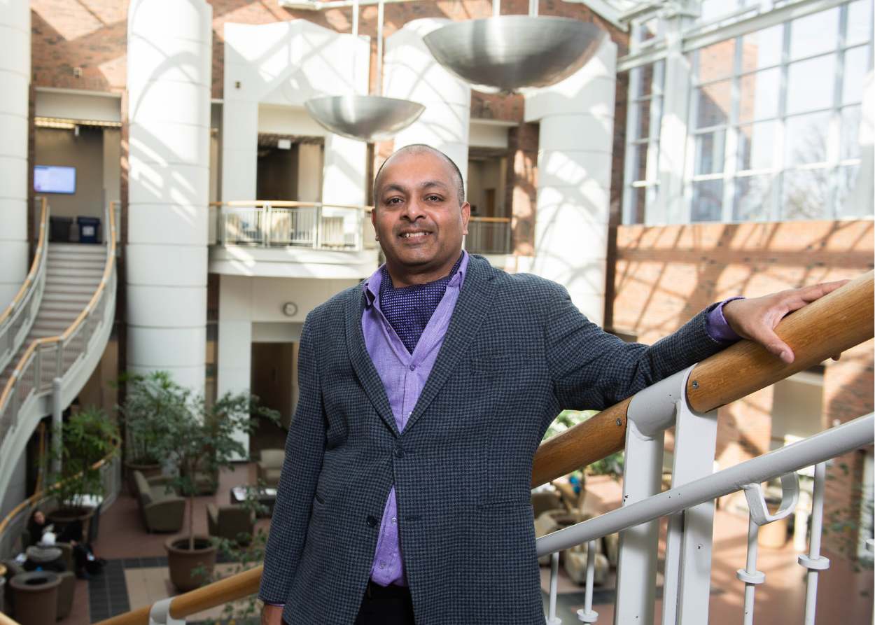 Ram Mohan standing on stairs at IWU's Center for Natural Sciences