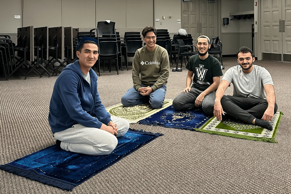 Muslim Student Association members sit on rugs for prayer meeting