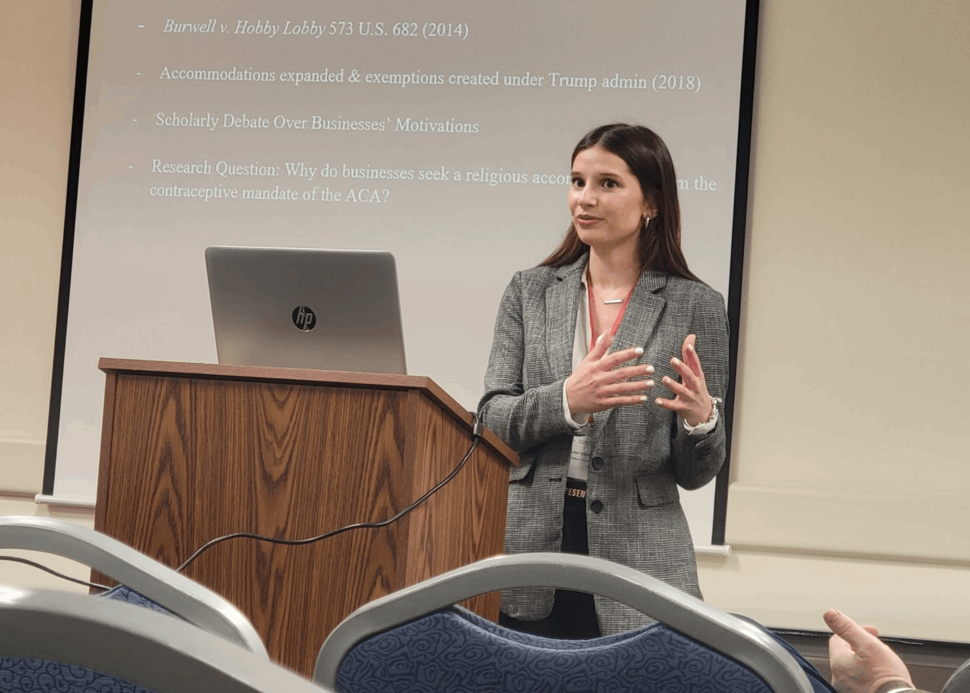 Rachel Williams '23 stands at a podium presenting her research project