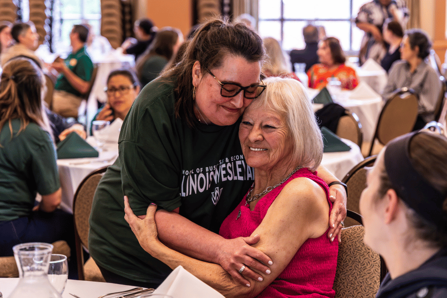 Two employees embracing during luncheon