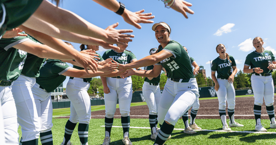 softball student getting high fives from team mates on the field