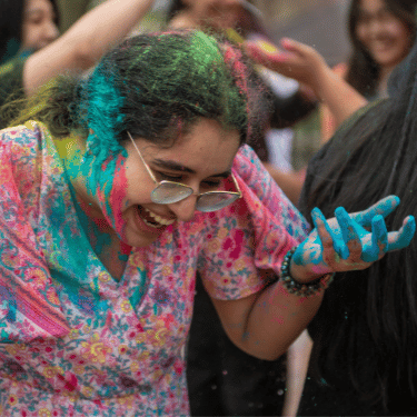 Student with colored powder celebrating Holi