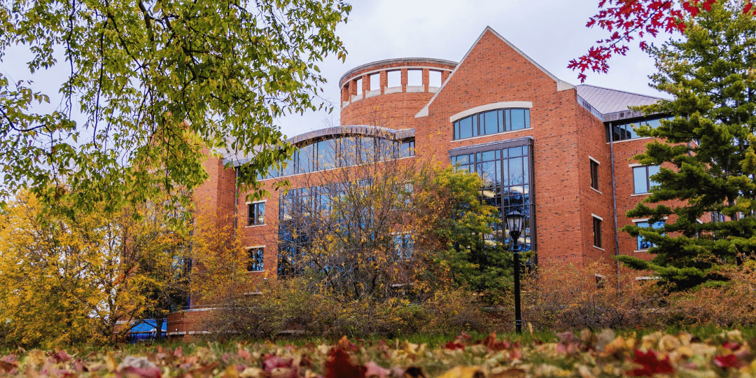 IWU's Ames Library framed by autumn leaves