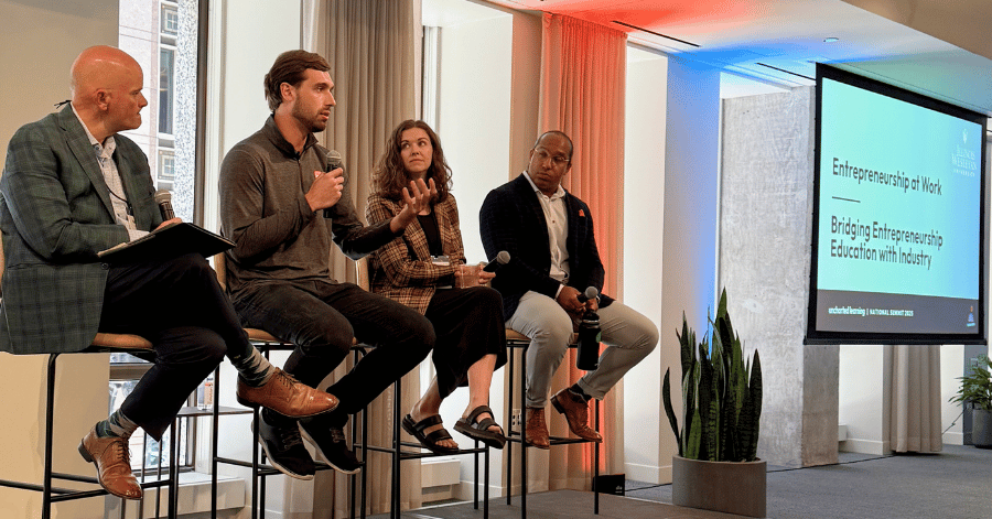 IWU alumni seated and holding microphones during a panel event