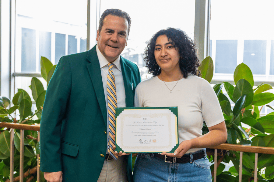 IWU President Sheahon Zenger presents the 2025 Technos International Award to Nathalie Romero '25