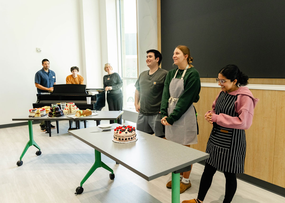 A group presents their gender reveal cake.
