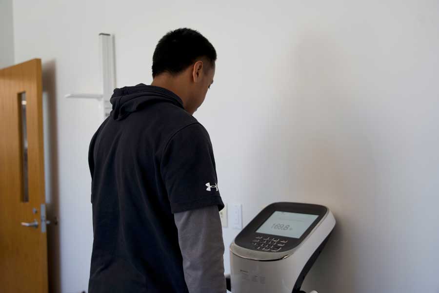 Male student standing on InBody machine