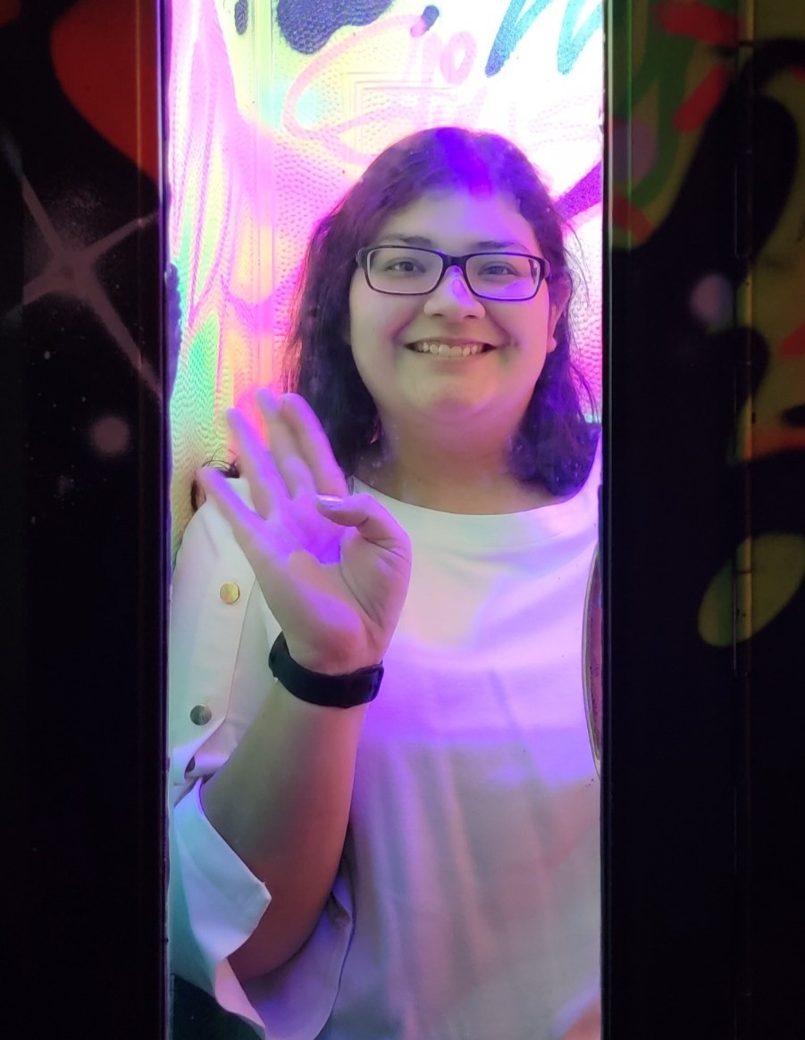 Smiling woman in front of a neon art background