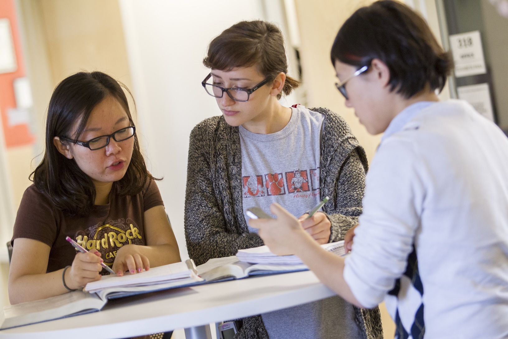 Three students working in a classroom.