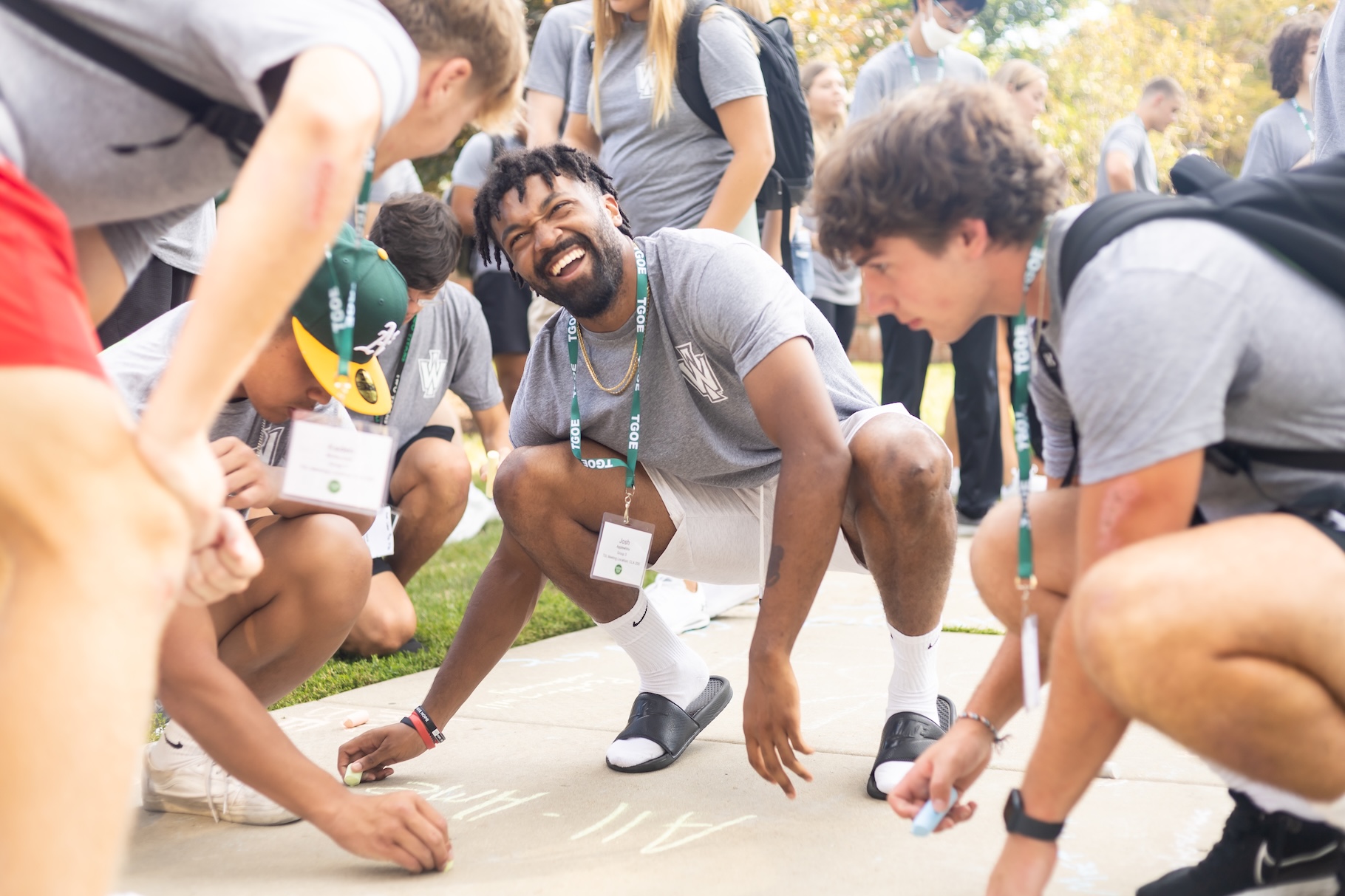 Students writing on sidewalk with chaulk.